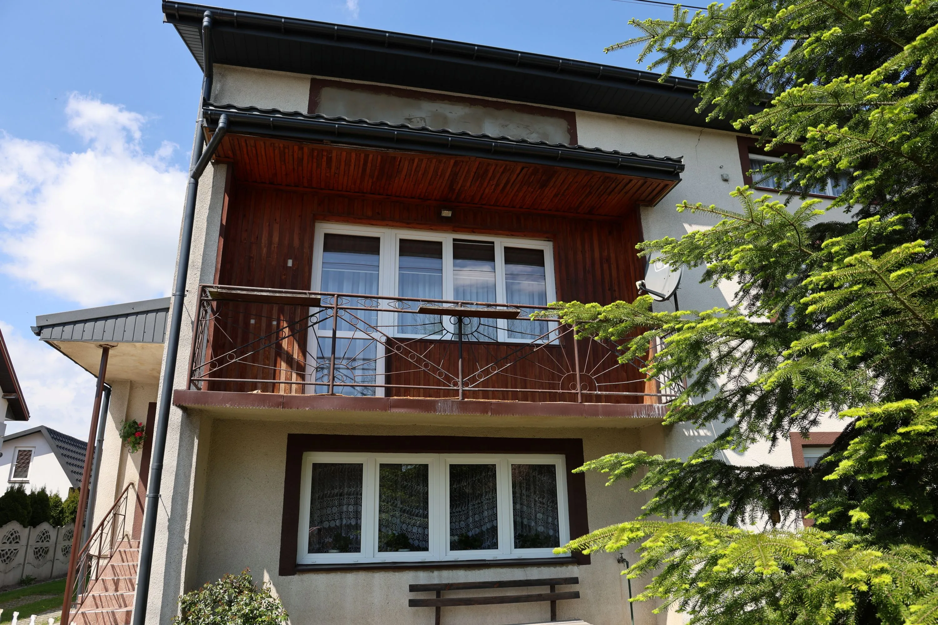 Budynek Agroturystyki u Eli z balkonem oraz widokiem na zielony ogród.