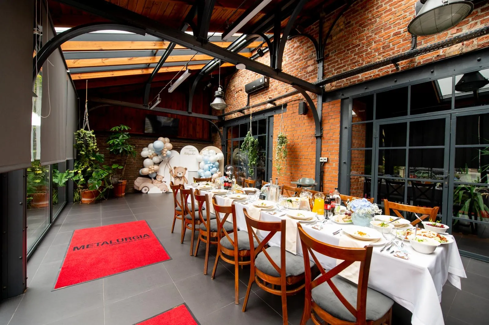 Kameralna sala restauracji Metalurgia przygotowana na przyjęcie rodzinne z elegancko nakrytym stołem i dekoracjami okolicznościowymi.