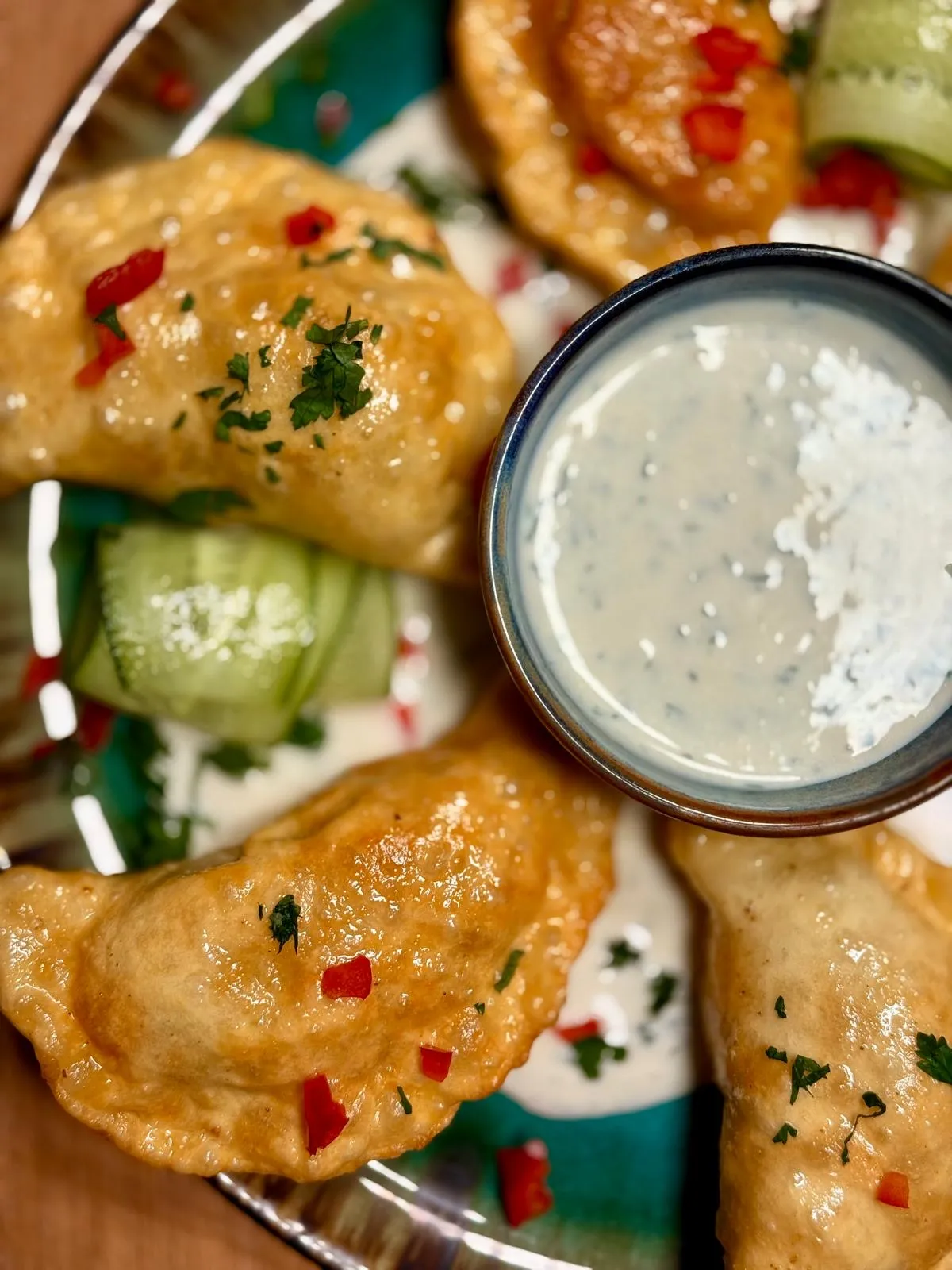 Ręcznie lepione pierogi podawane z kremowym sosem i świeżymi dodatkami w restauracji Metalurgia.