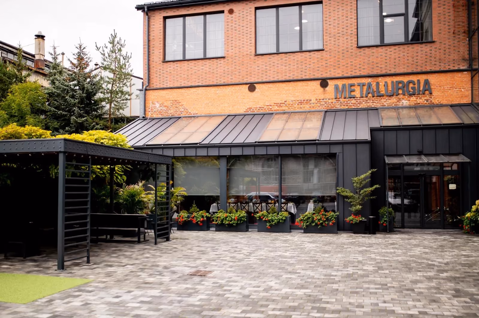 Wejście do restauracji Metalurgia mieszczącej się w zrewitalizowanym budynku o industrialnym charakterze.