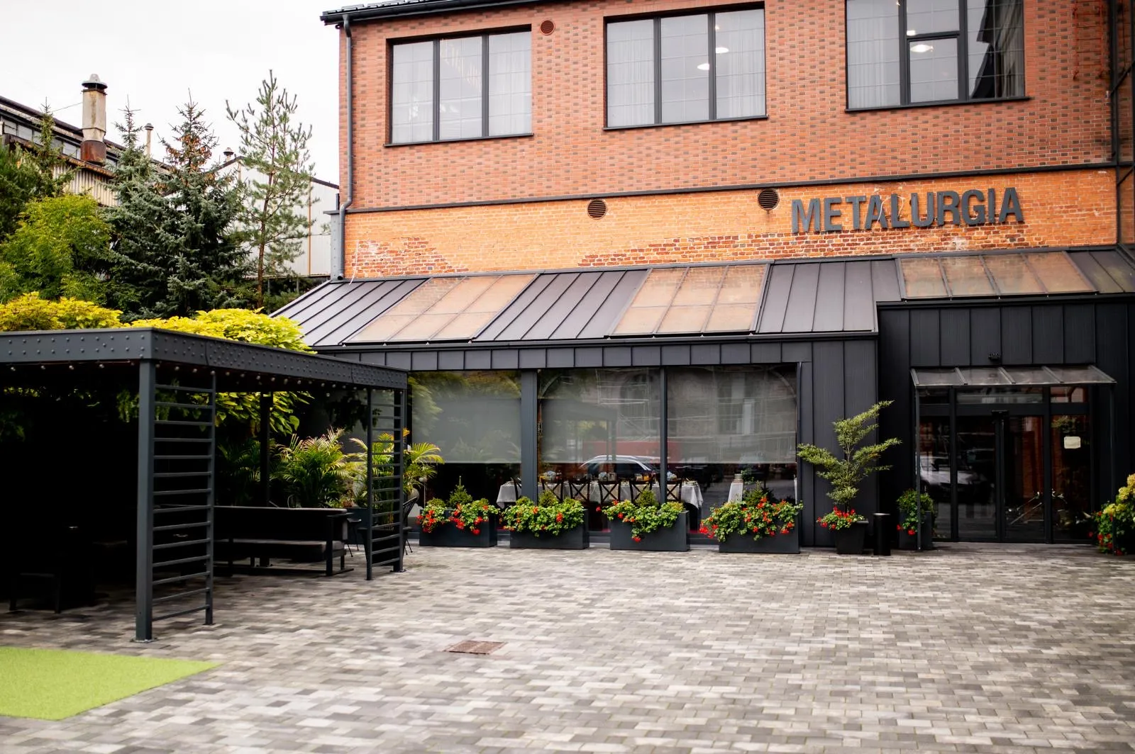 Wejście do restauracji Metalurgia mieszczącej się w zrewitalizowanym budynku o industrialnym charakterze.