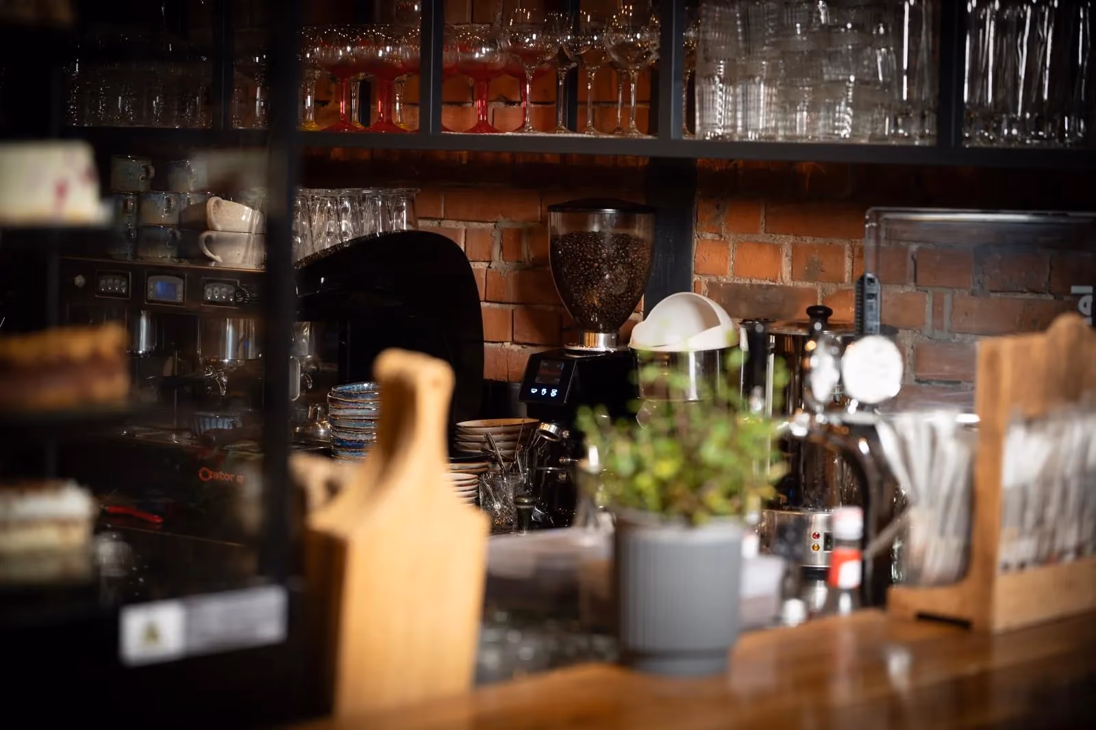 Stylowy bar restauracji Metalurgia z ekspresem do kawy, szkłem barowym i industrialnym wystrojem wnętrza.