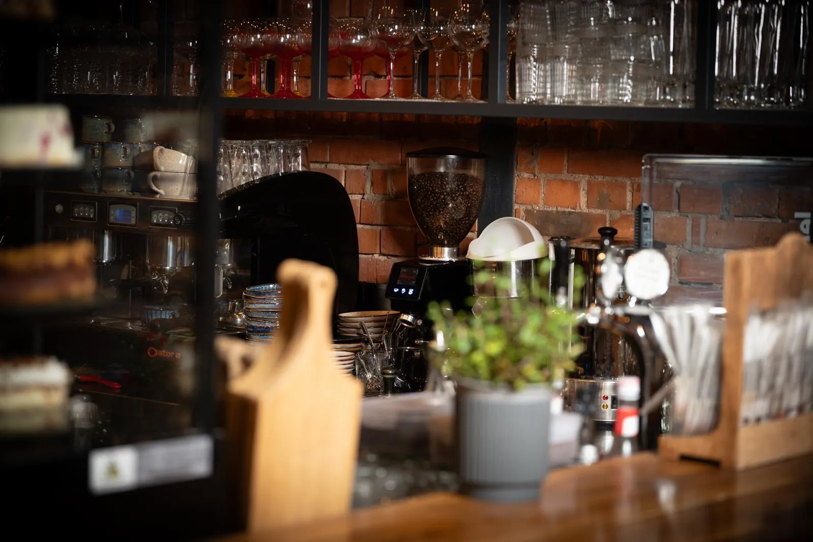 Stylowy bar restauracji Metalurgia z ekspresem do kawy, szkłem barowym i industrialnym wystrojem wnętrza.