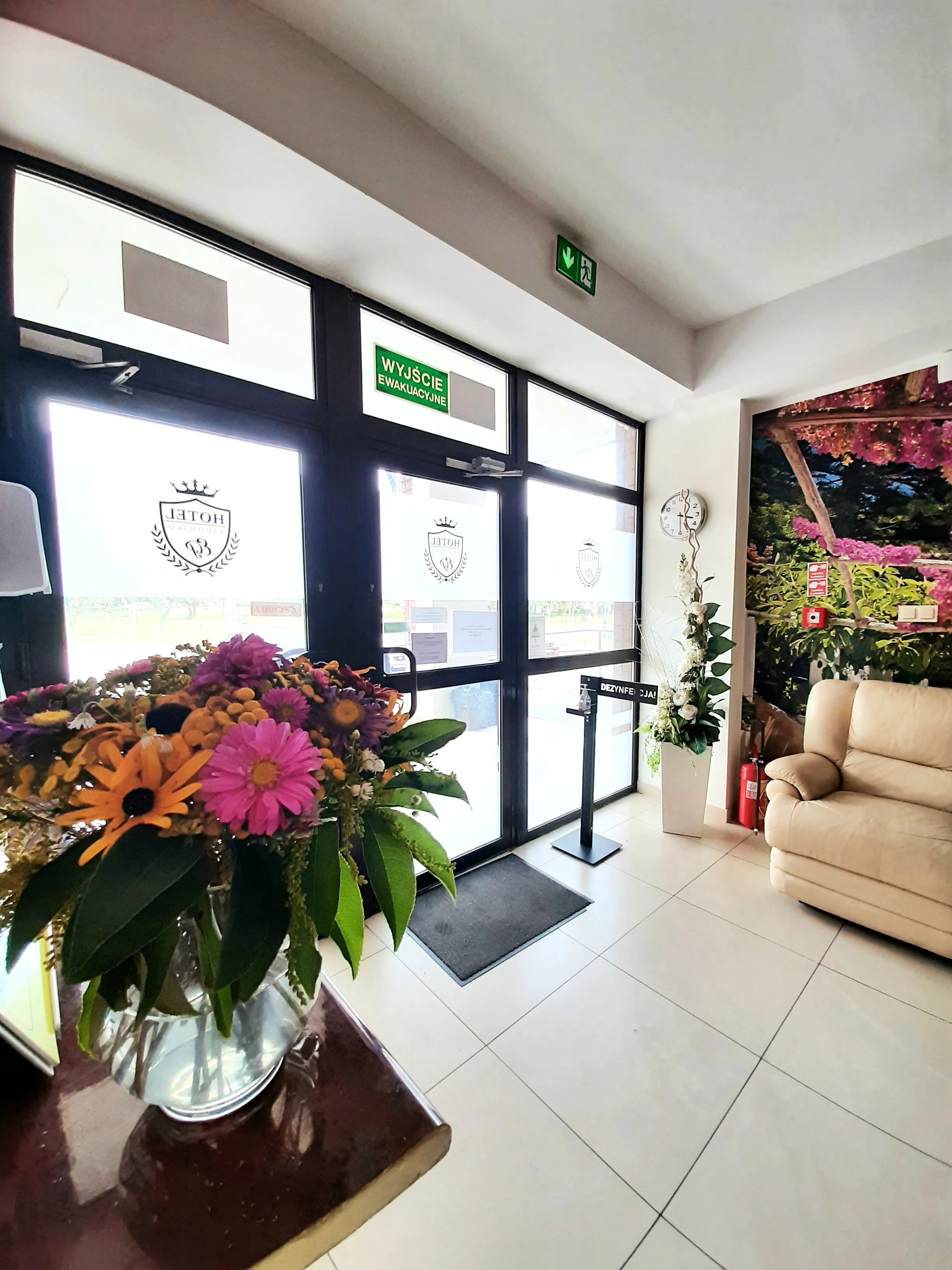 Jasny hol wejściowy Hotelu Radomsko z recepcją, wygodnymi fotelami oraz przestronnym wejściem do obiektu.