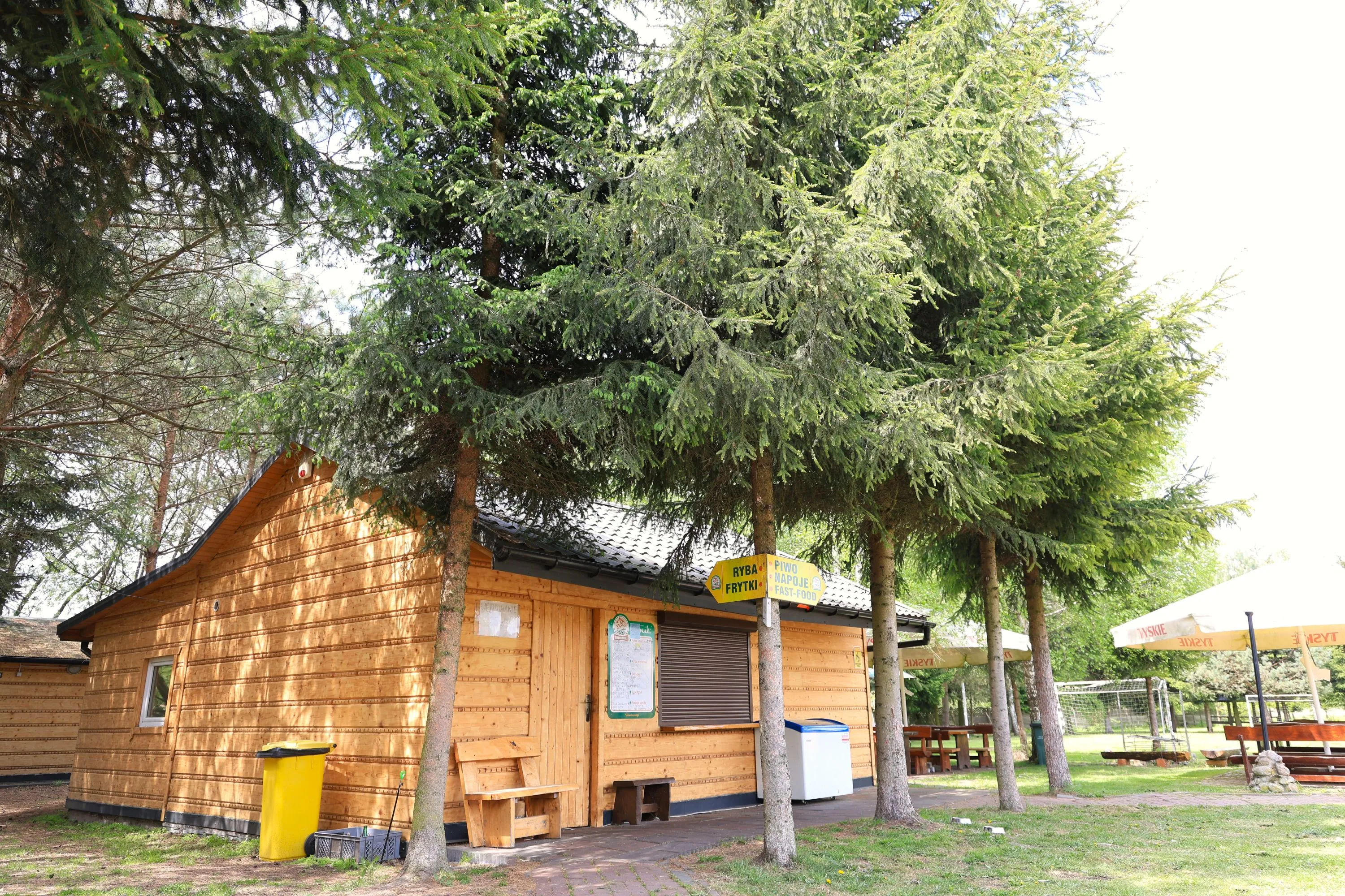 Drewniane zabudowania i taras nad wodą tworzące spokojną atmosferę Smażalni Ryb Folwarki.