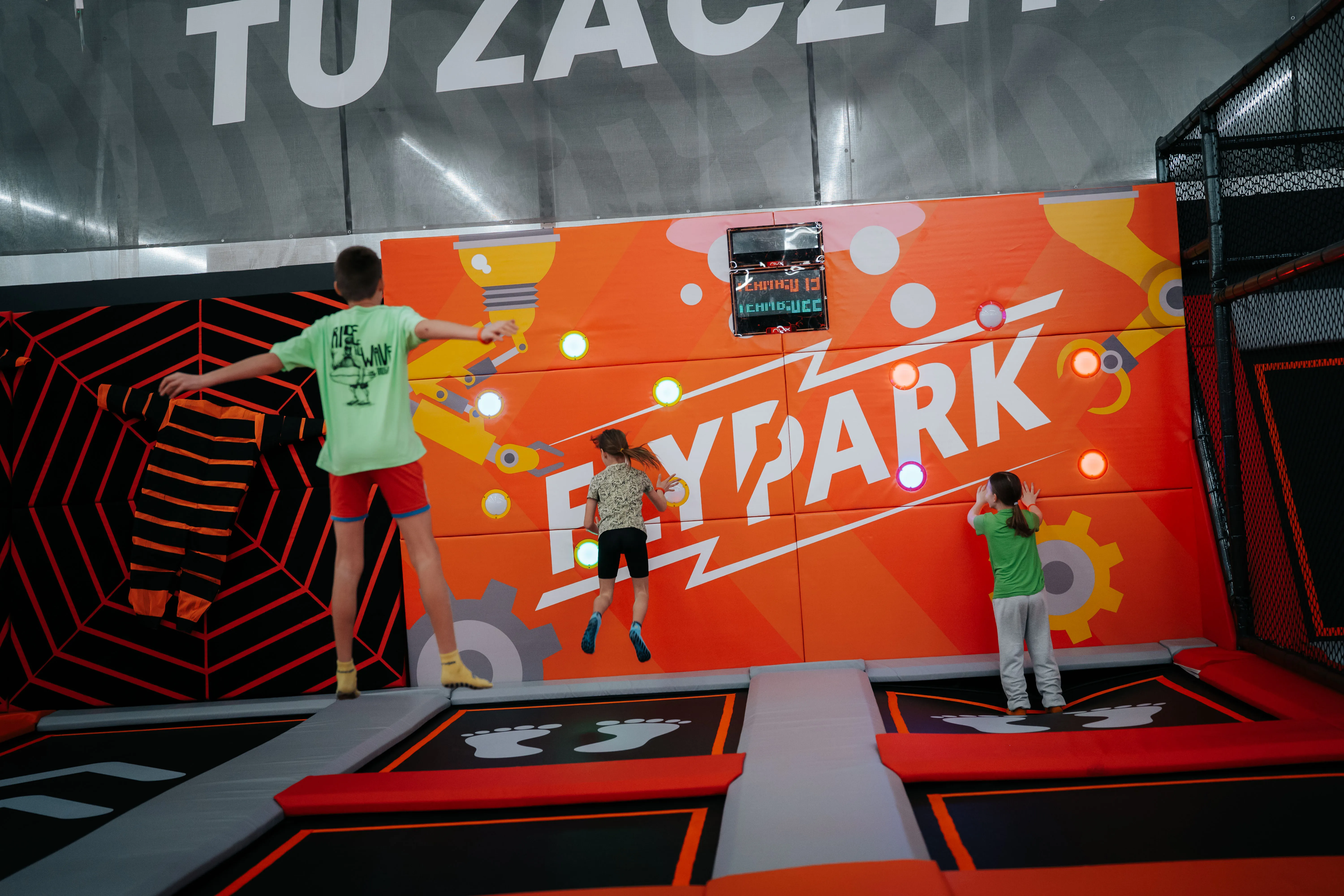 Dzieci bawiące się na trampolinach interaktywnych w FlyPark. Aktywna rozrywka rozwijająca koordynację ruchową, refleks i sprawność fizyczną poprzez zabawę.