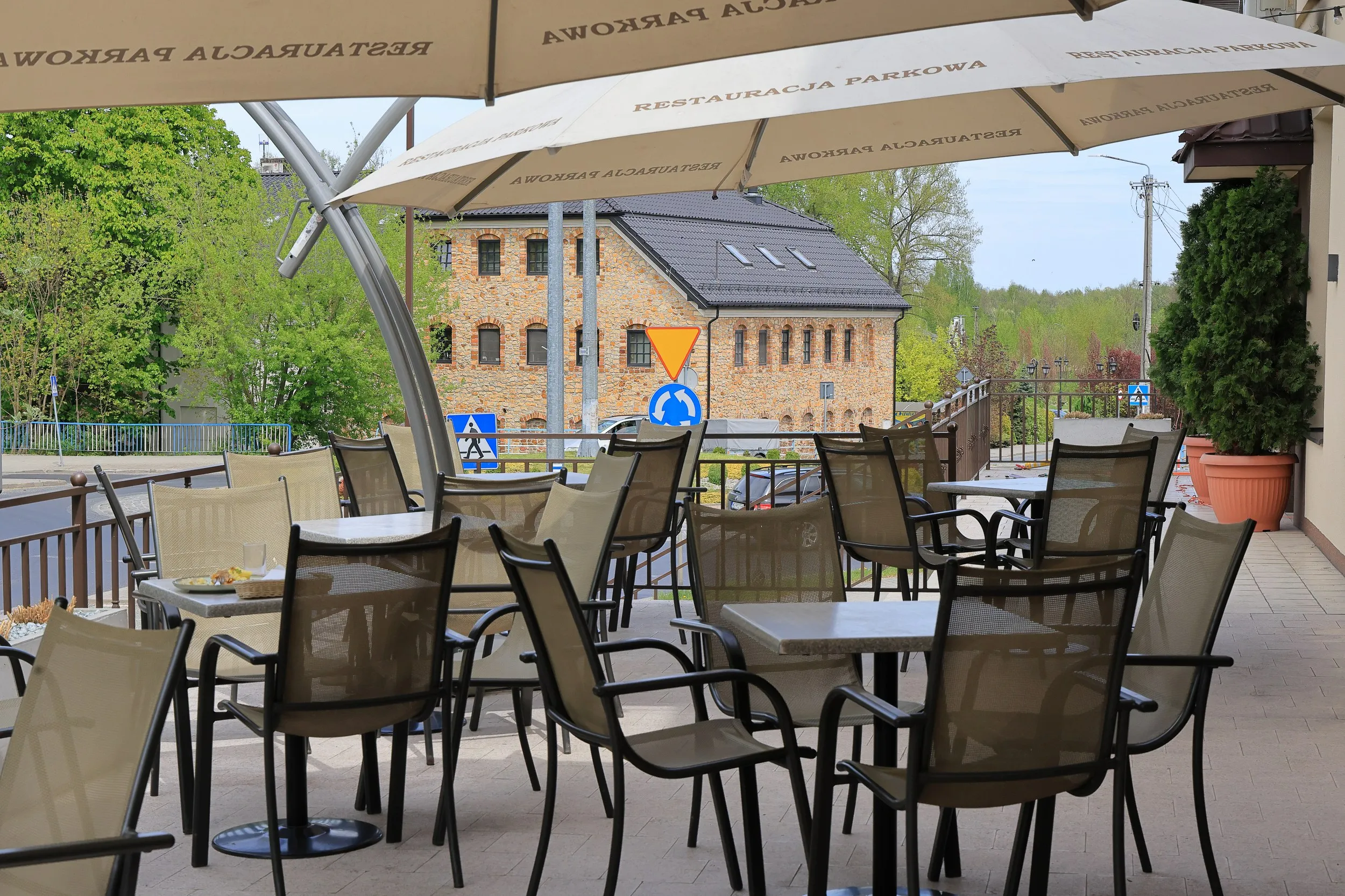 Taras restauracyjny z miejscami do siedzenia na świeżym powietrzu i widokiem na okolicę.