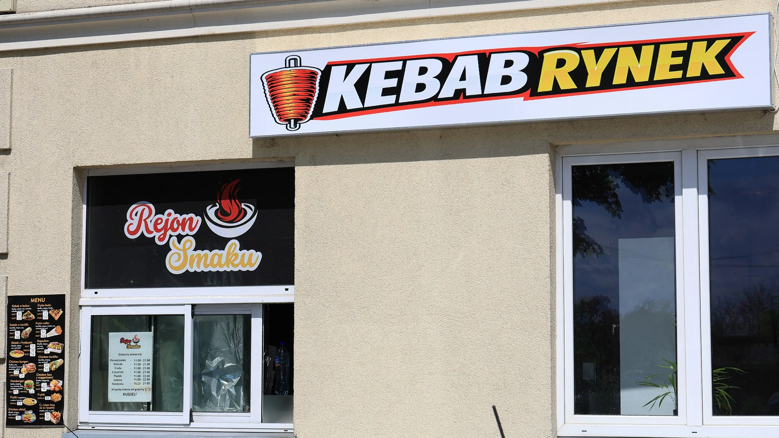 Szyld Kebab Rynek i punkt gastronomiczny Rejon Smaku oferujący kebaby oraz dania fast food.