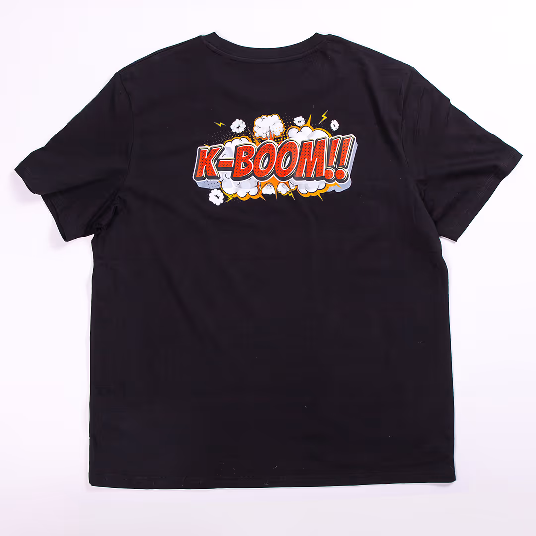 Zwarte T-shirt met een kleurrijke K-BOOM!! opdruk in stripstijl aan de achterkant.