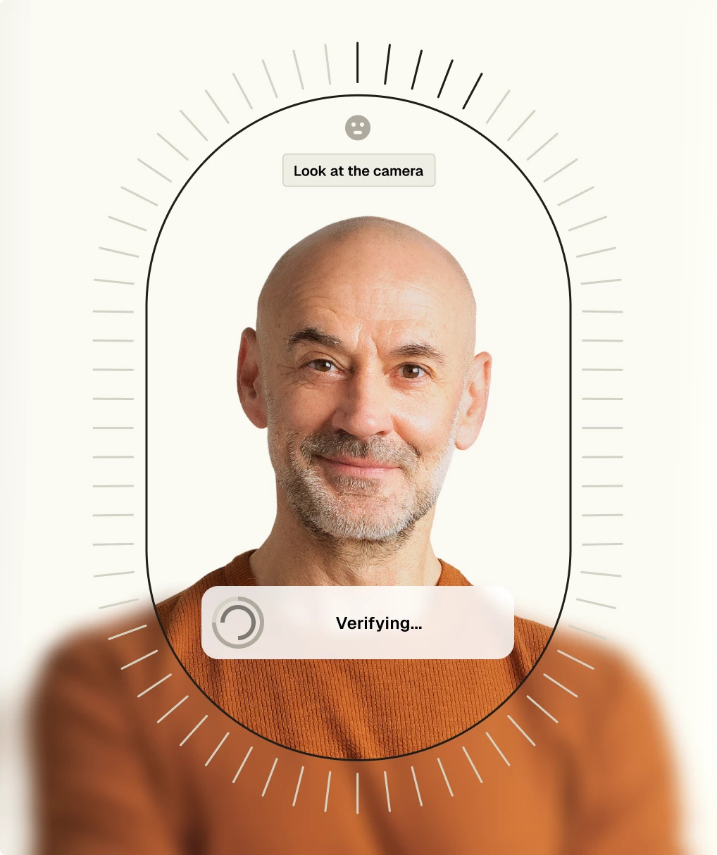 Middle-aged bald man with a beard looking at the camera during facial recognition verification on a digital interface.