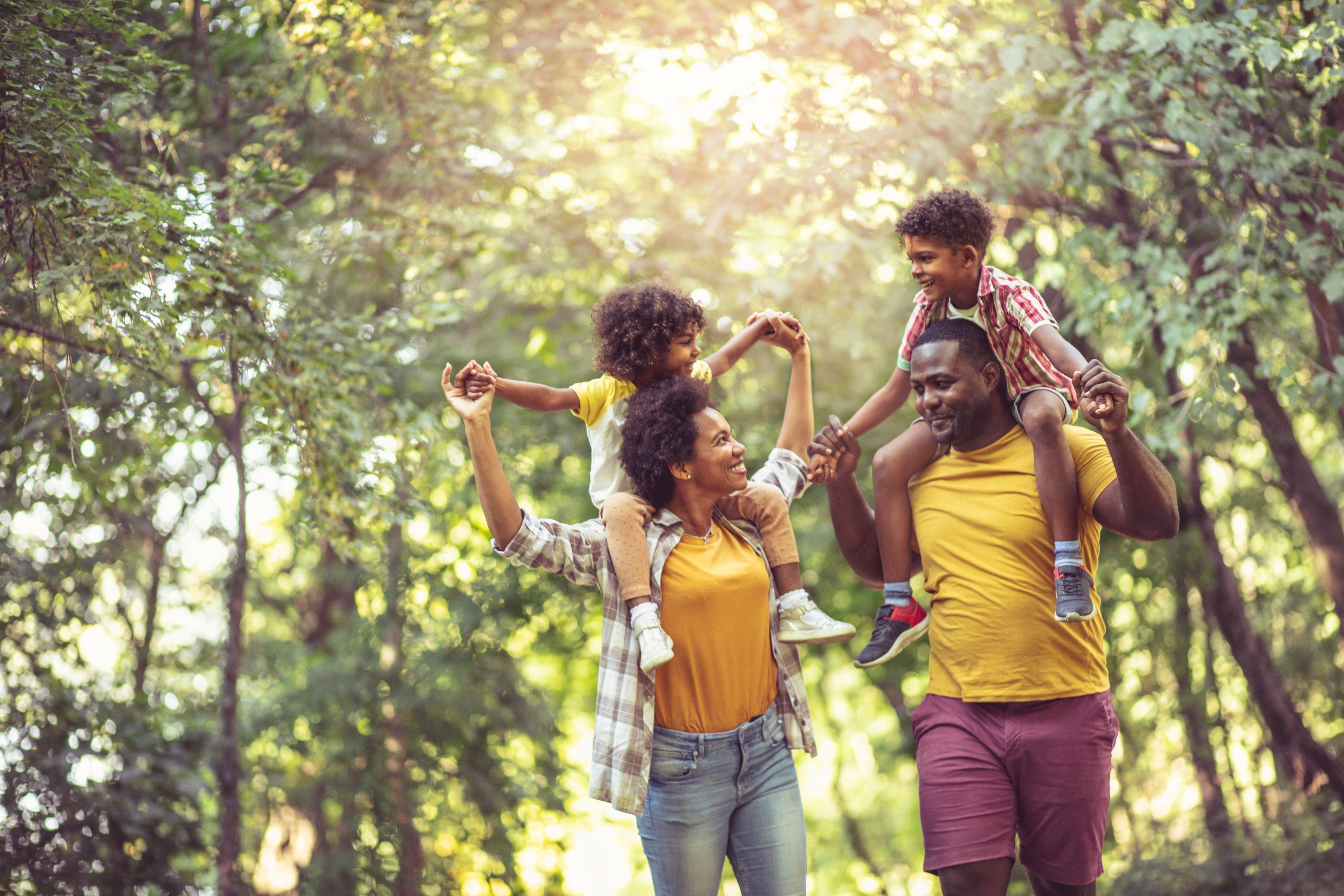 Mom dad and kids walking through a park stock image