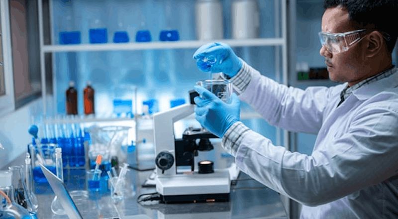 Chercheur manipulant des échantillons en laboratoire dans le cadre d'analyses scientifiques et pharmaceutiques.
