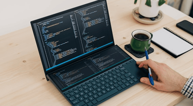 Développeur travaillant sur le code d'une application informatique depuis un poste de travail.