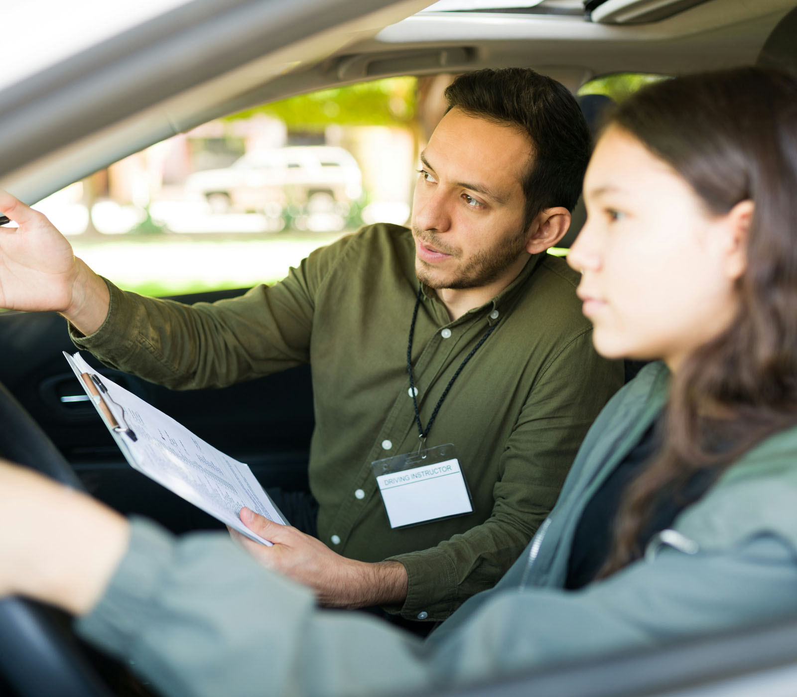Man teaching young teenage girl how to drive.