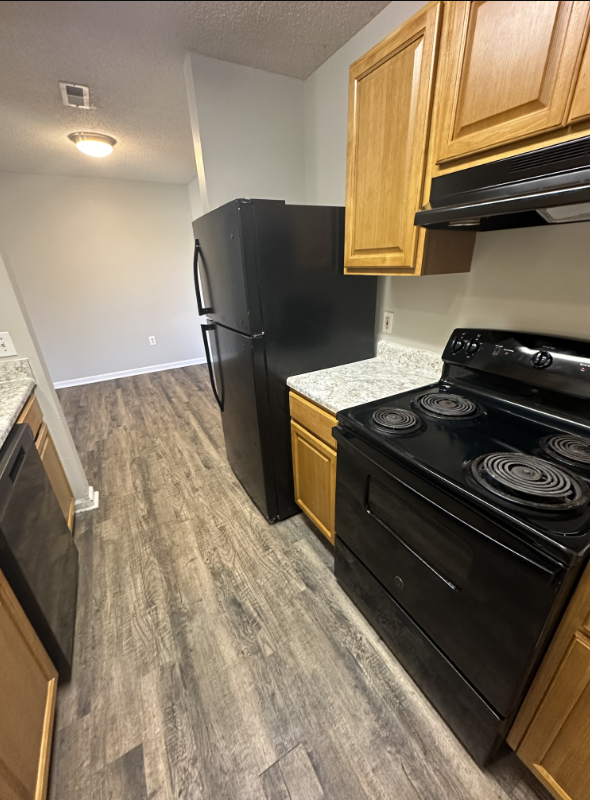 Kitchen with brown wood cabinets and black appliances