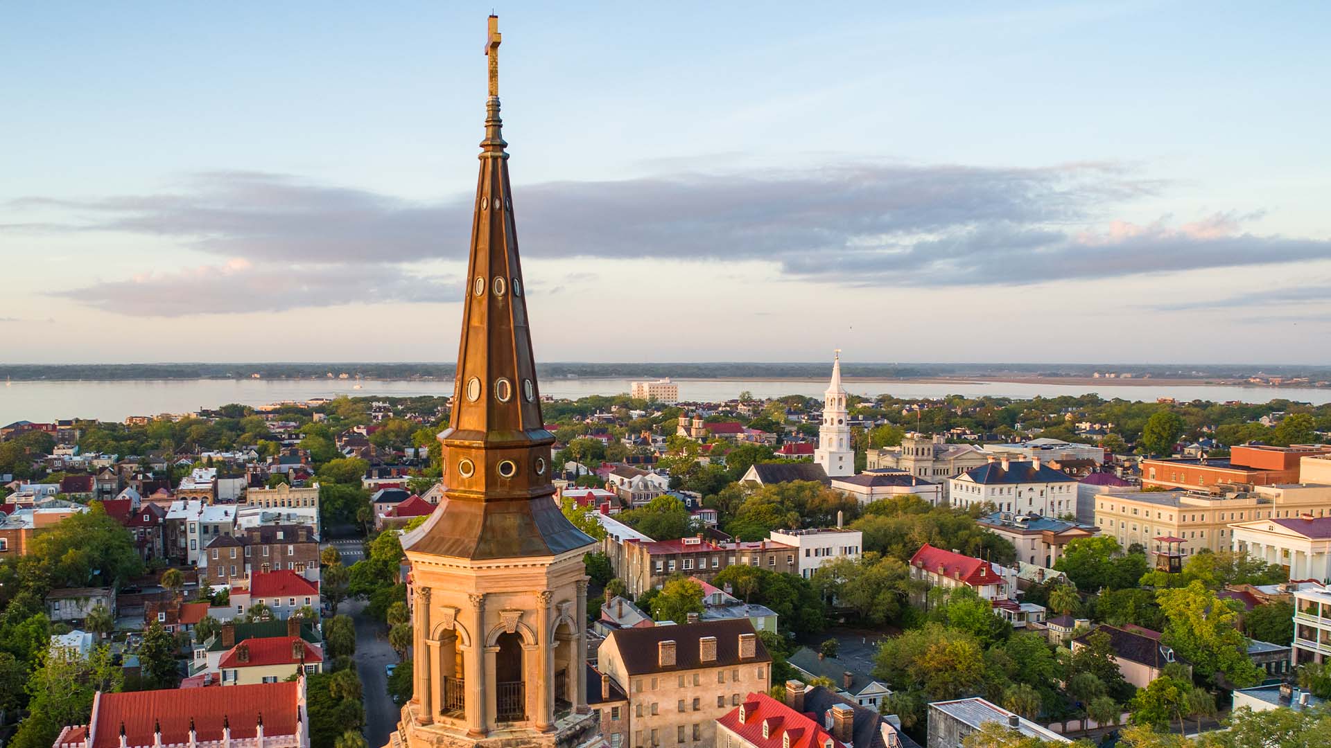 An aerial view of Charleston, SC from just behind an iconic church steeple.