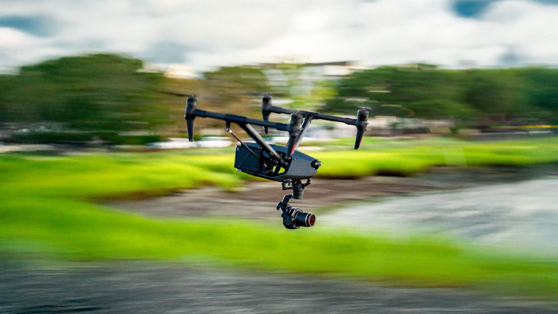Image of a drone flying at high speed with the camera in focus and the background blurred.