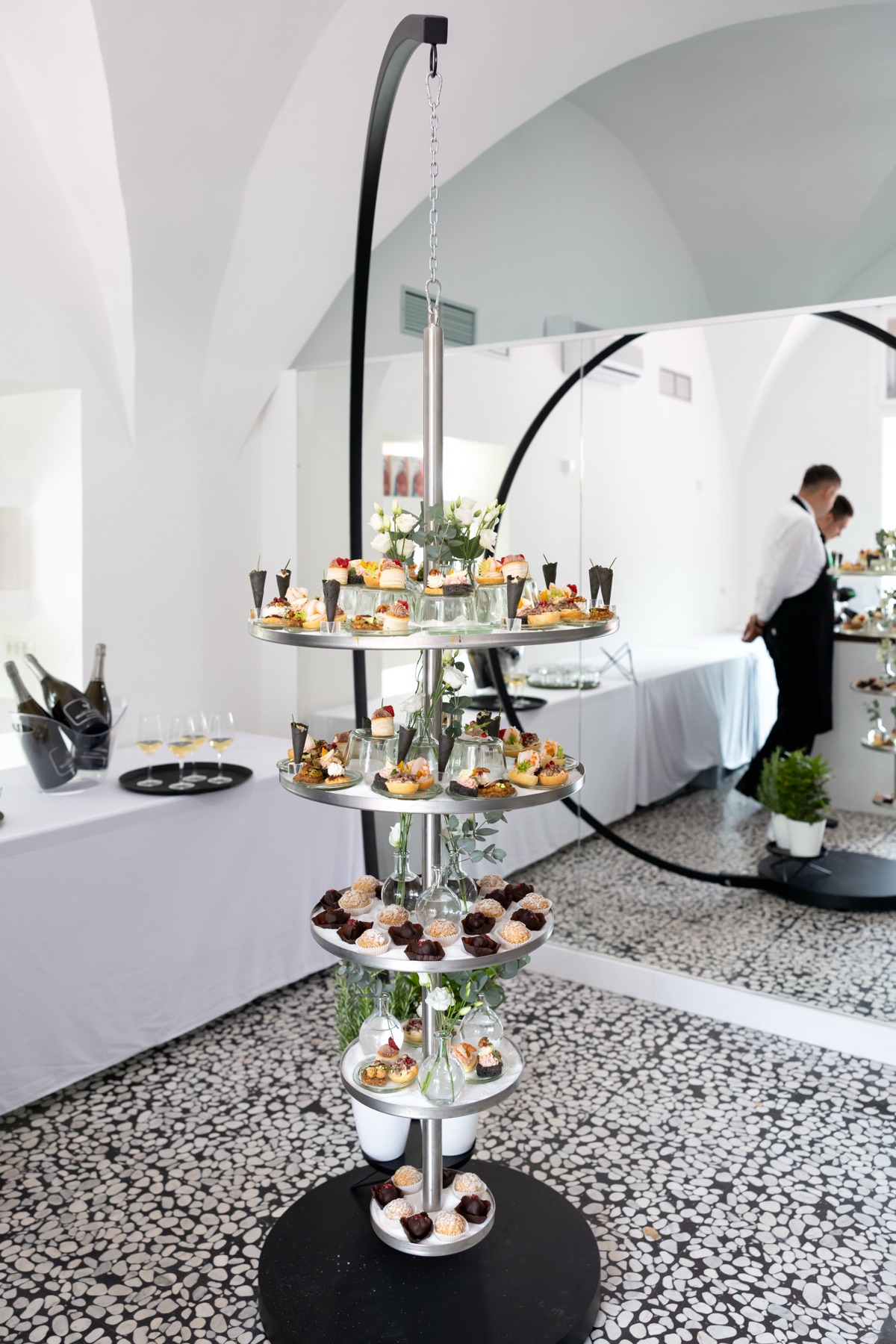 Catering etažni stolp s prigrizki in sladicami pod vaultanim stropom — predstavitev knjige »Toni bi poznal naslov te knjige«, Ljubljana