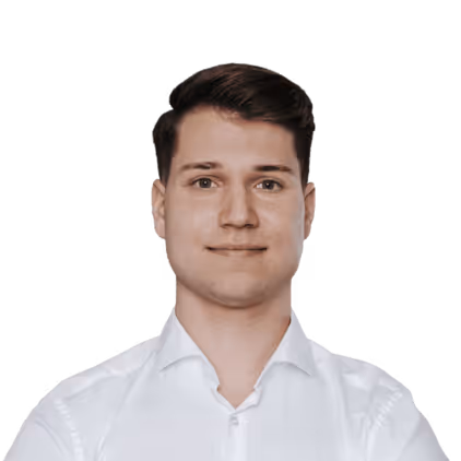 Porträt eines jungen Mannes mit kurzen braunen Haaren, der ein weißes Hemd trägt und in die Kamera lächelt.