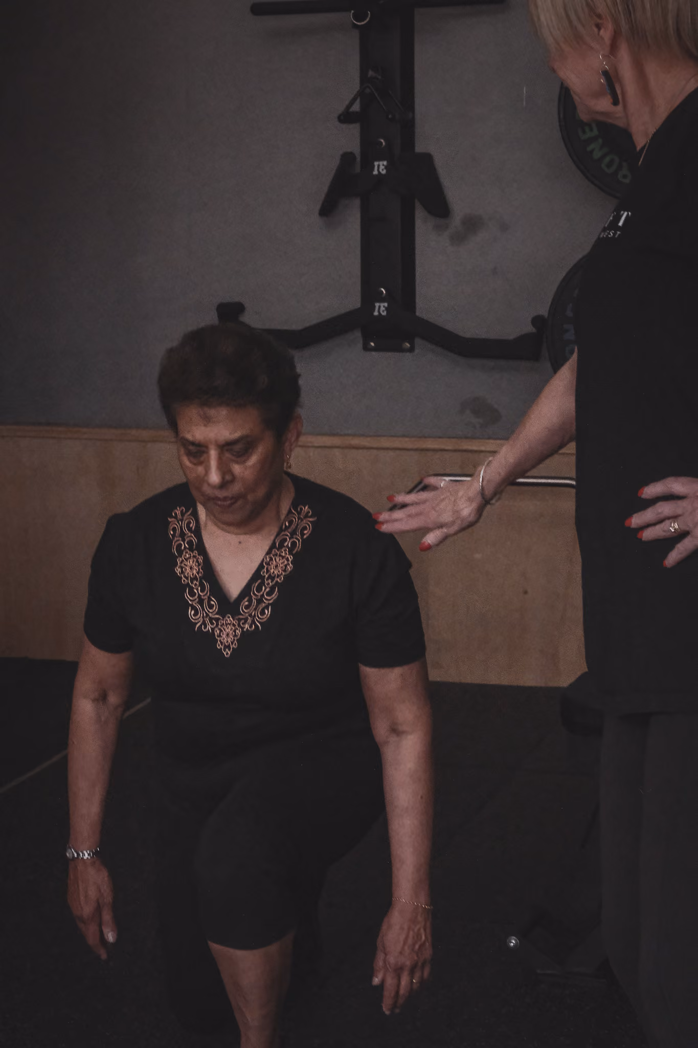 Exercise Physiologist guiding a client through a leg curl in a Bones & Balance session