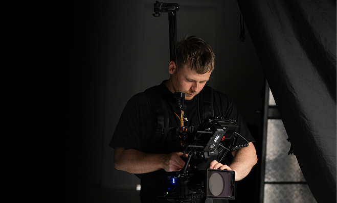 A man handling a strapped video camera