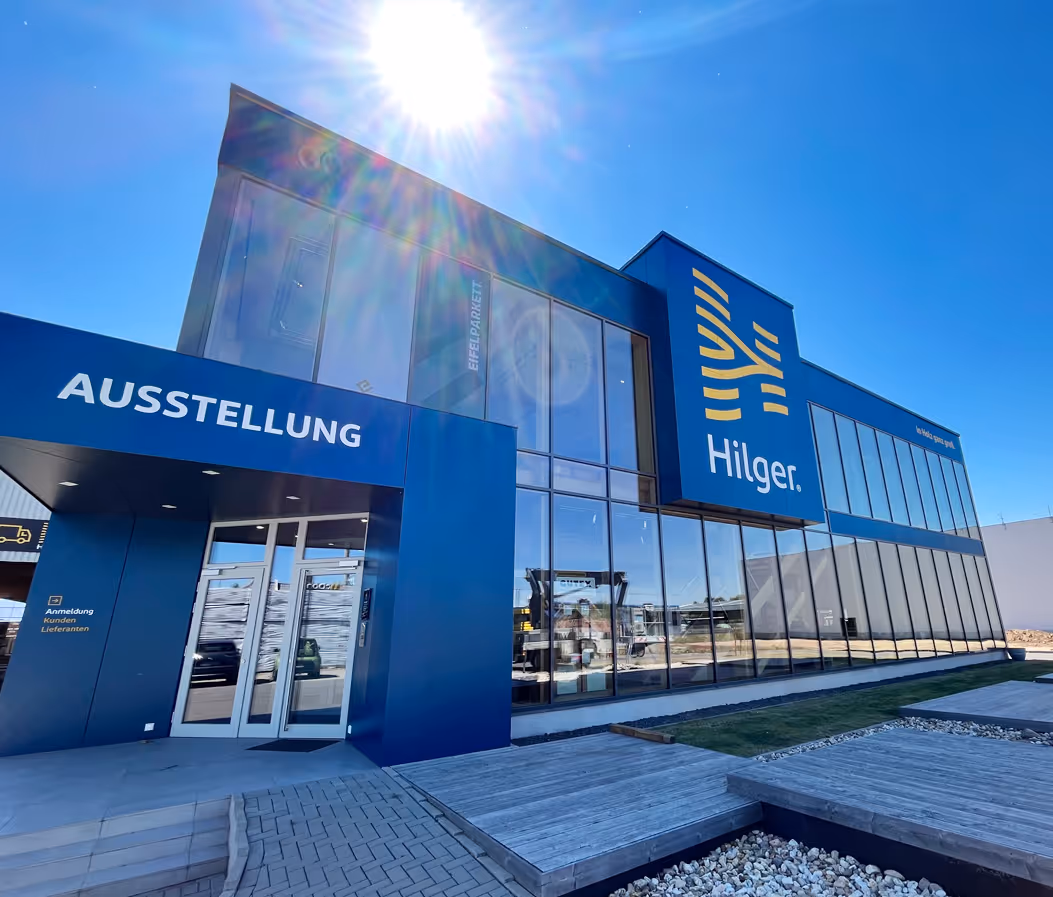 Das Bild zeigt die Eingangsfront von Hilger Holz. Es ist ein Ausstellungs-Schuld zu sehen.