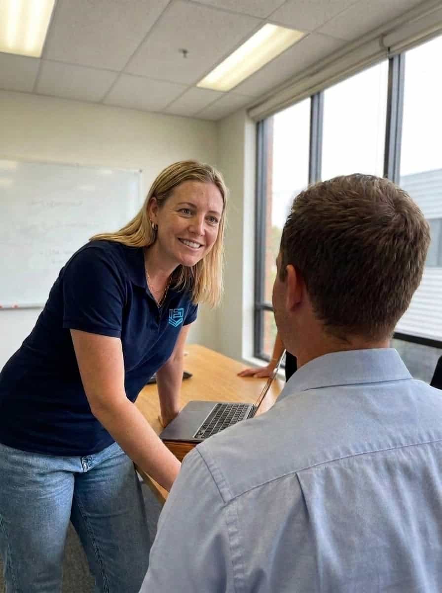 Elscomm staff member handing a configured laptop to a client
