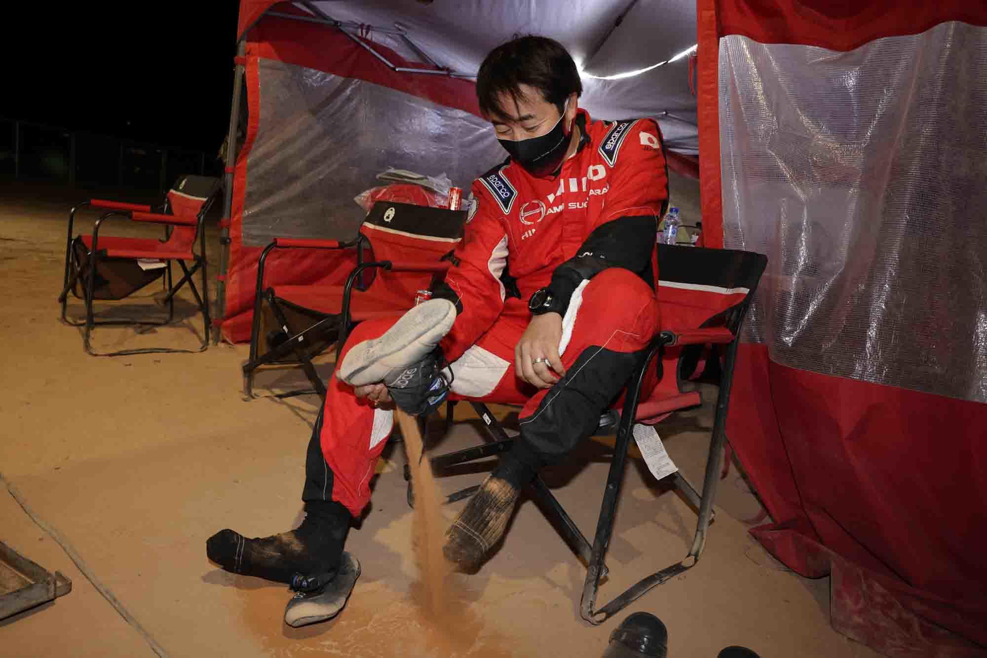 Hirokazu Somemiya shakes out sand from his boots