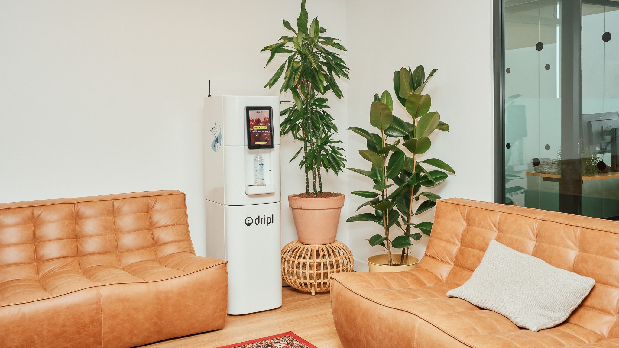 Dripl watertap in een open kantoor met warme zithoek