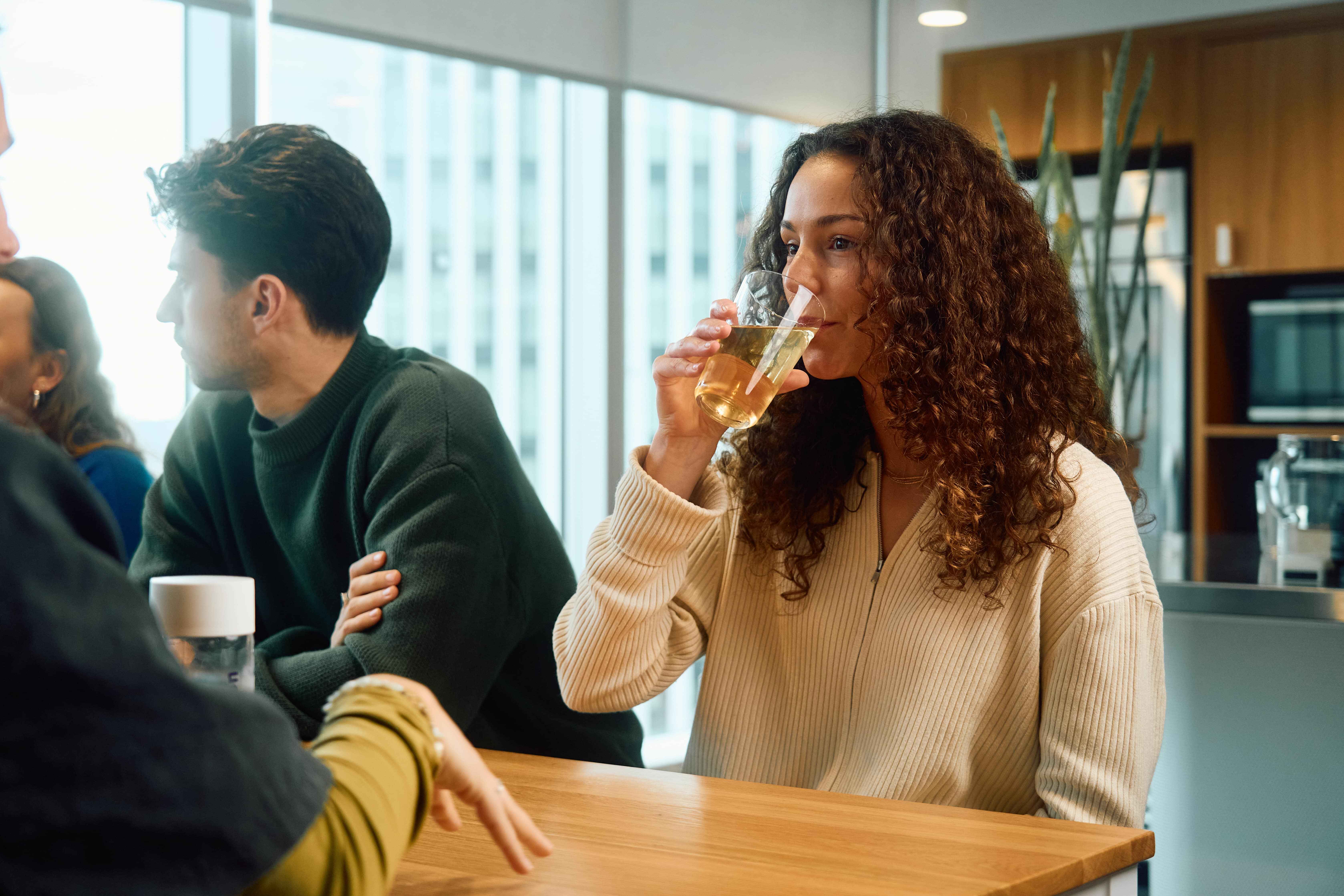 Medewerkers nemen samen een pauze met een functionele drink van Dripl op de werkvloer