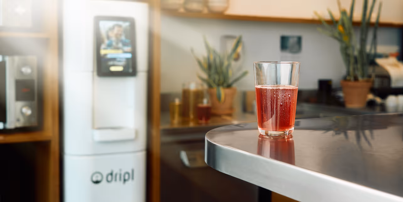A Dripl refill point, the smartest water dispenser, and a glass filled with healthy-flavored water. 