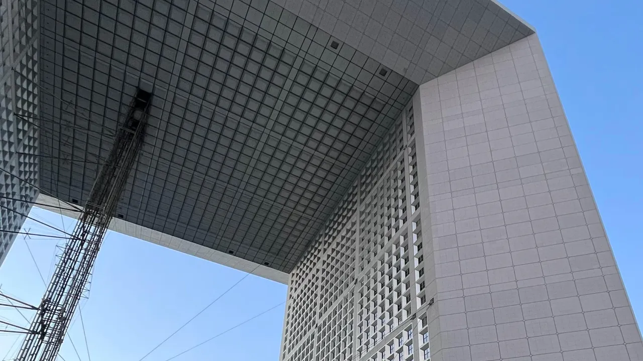 View from below of Tetmet France office building with an open square center under blue sky.