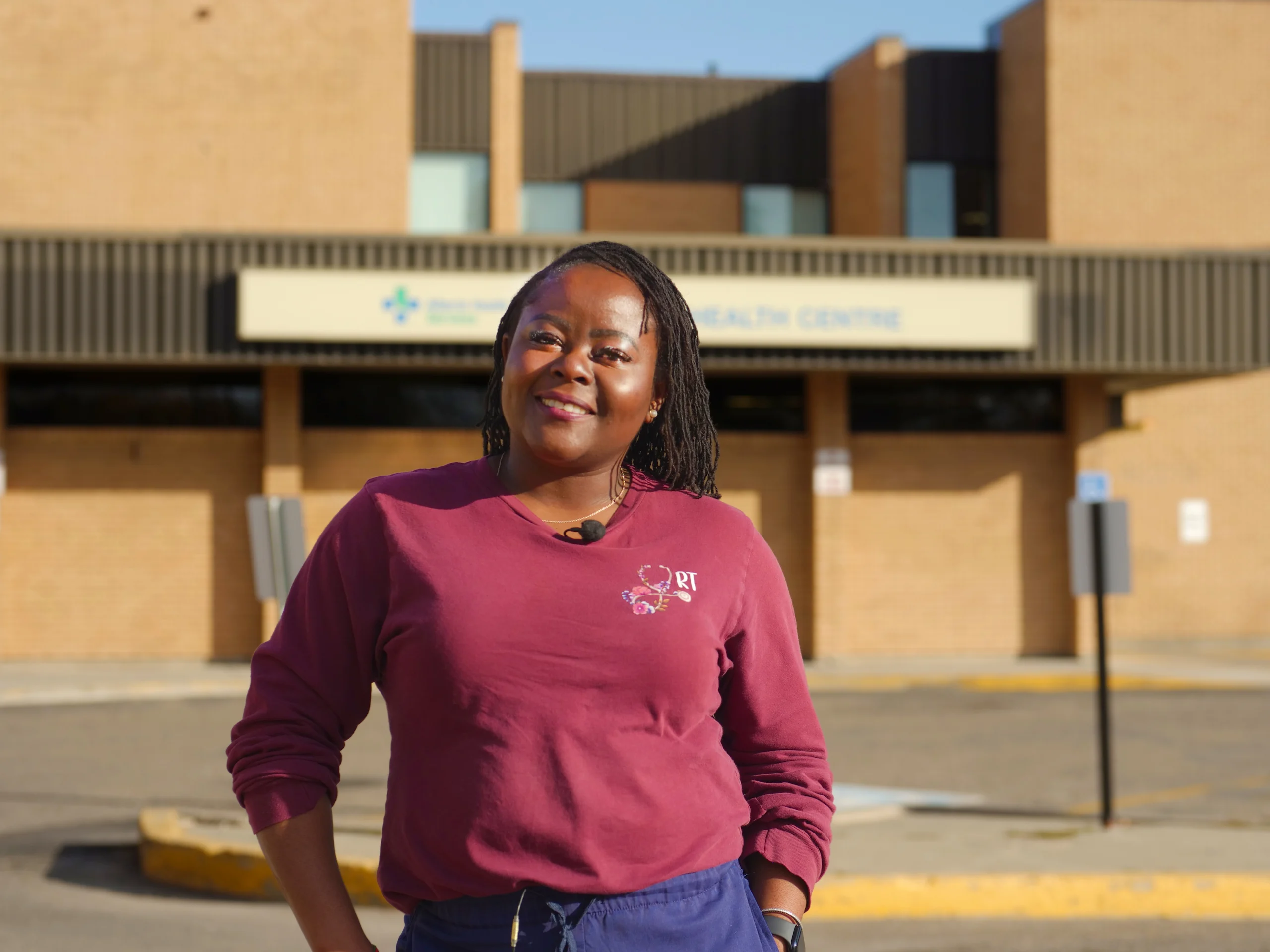 A female doctor standing in front of a hospital