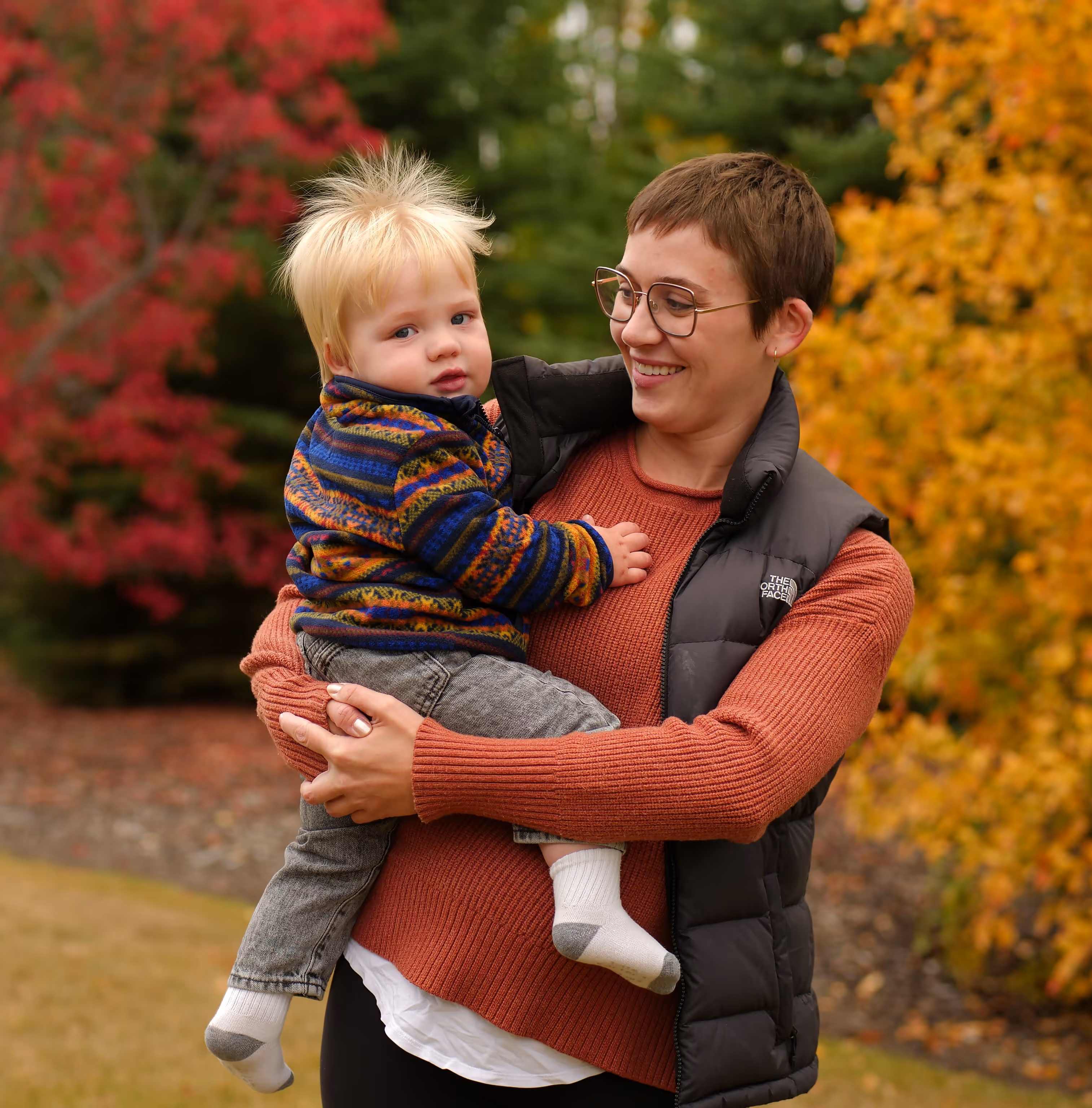 A woman holds her child while smiling