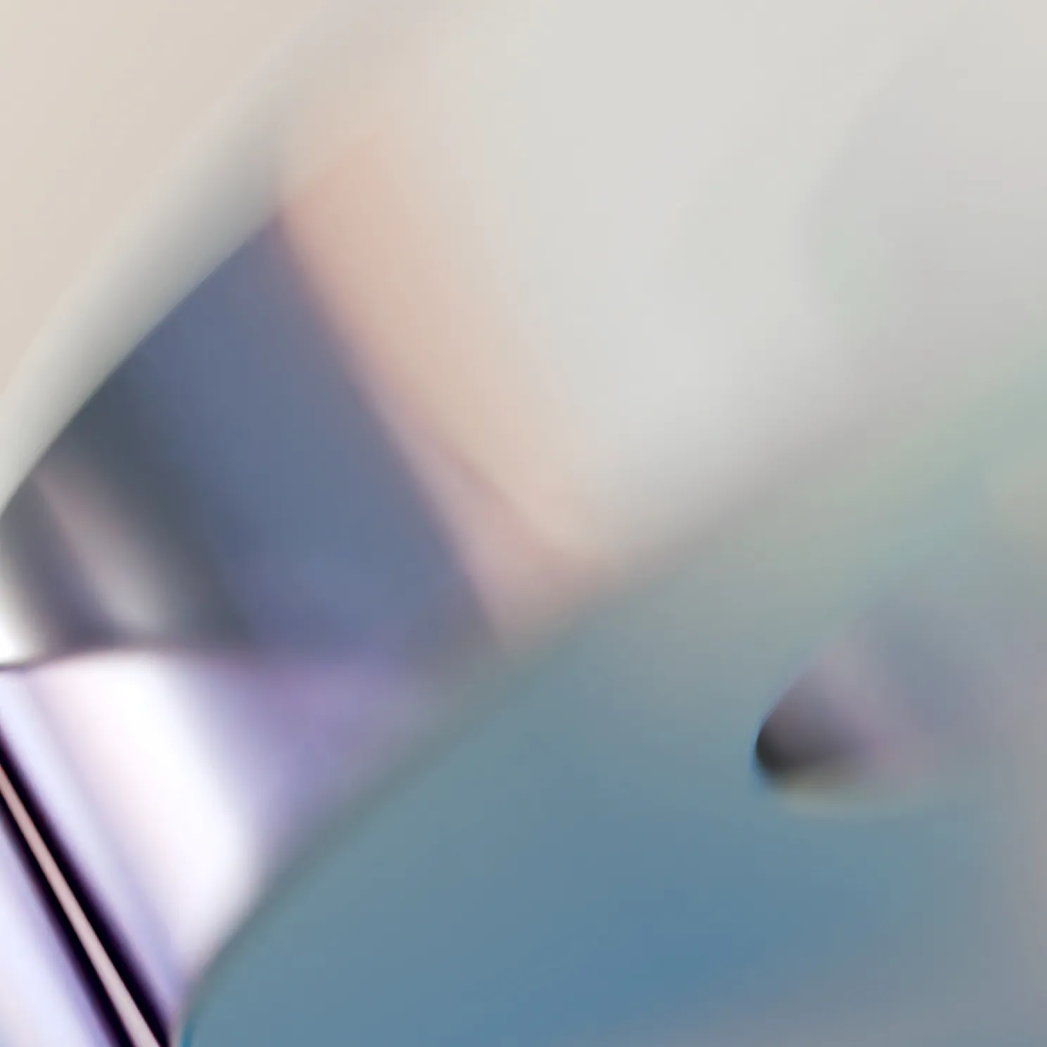 Abstract blurred image with soft pastel tones of blue, purple, and beige creating a smooth gradient effect.