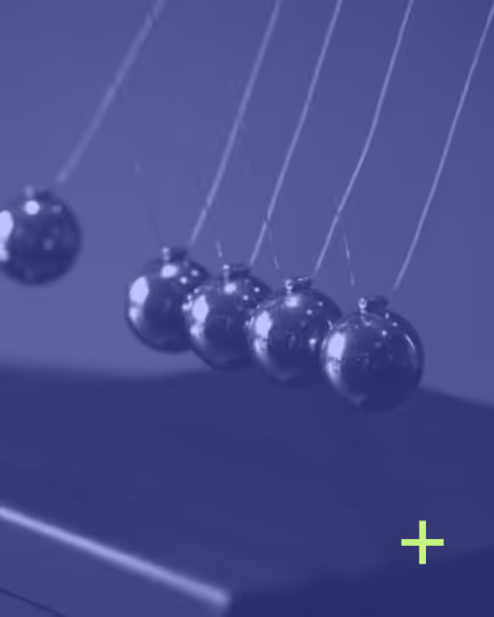 Newton's cradle showing swinging metal balls demonstrating momentum and energy transfer.
