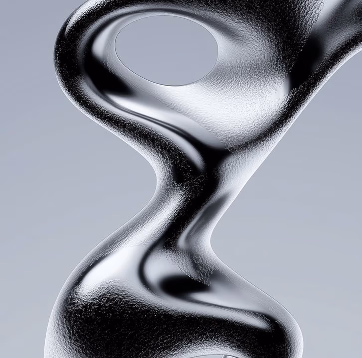 Close-up of a smooth, shiny, black abstract sculpture with flowing, organic curves and a hole near the top.