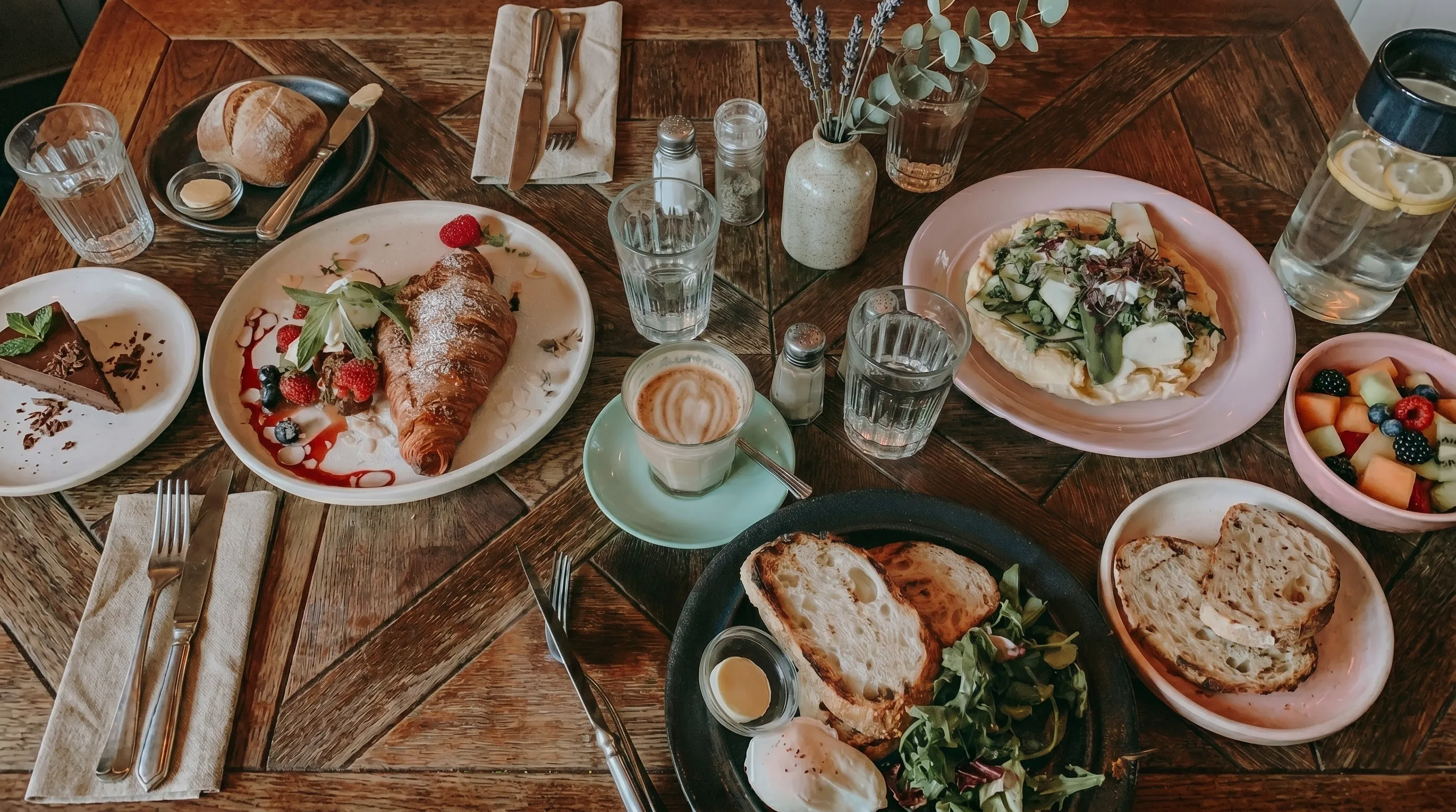 Elegant restaurant interior with dim lighting, wooden tables, and chairs. Ornate hanging lights create a warm ambiance. Artistic wall decor adds sophistication.