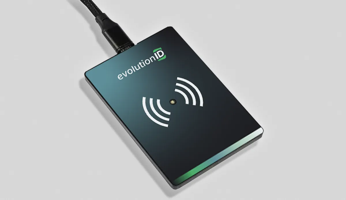 Schwarzer ELATEC – evolutionID-Smartcard-Lesegerät mit angeschlossenem USB-Kabel auf weißem Untergrund.