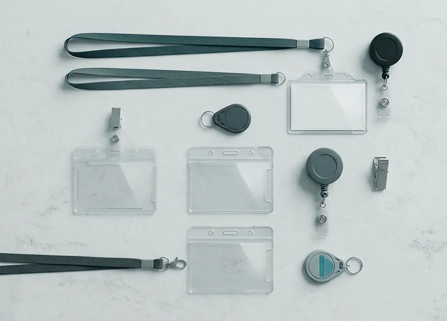 Various clear plastic ID badge holders, lanyards, retractable reels, and clips laid out on a white surface.