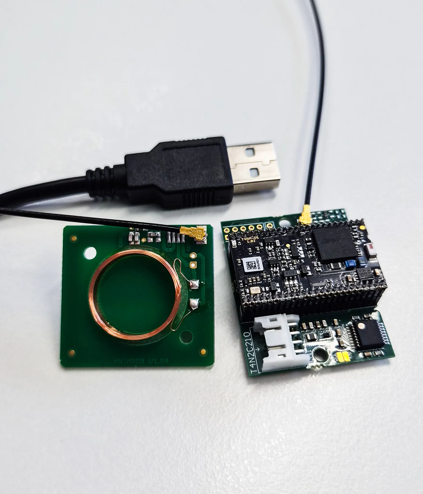 Zwei elektronische PCB-Module mit einer Antenne und einem USB-Kabel auf weißem Hintergrund.