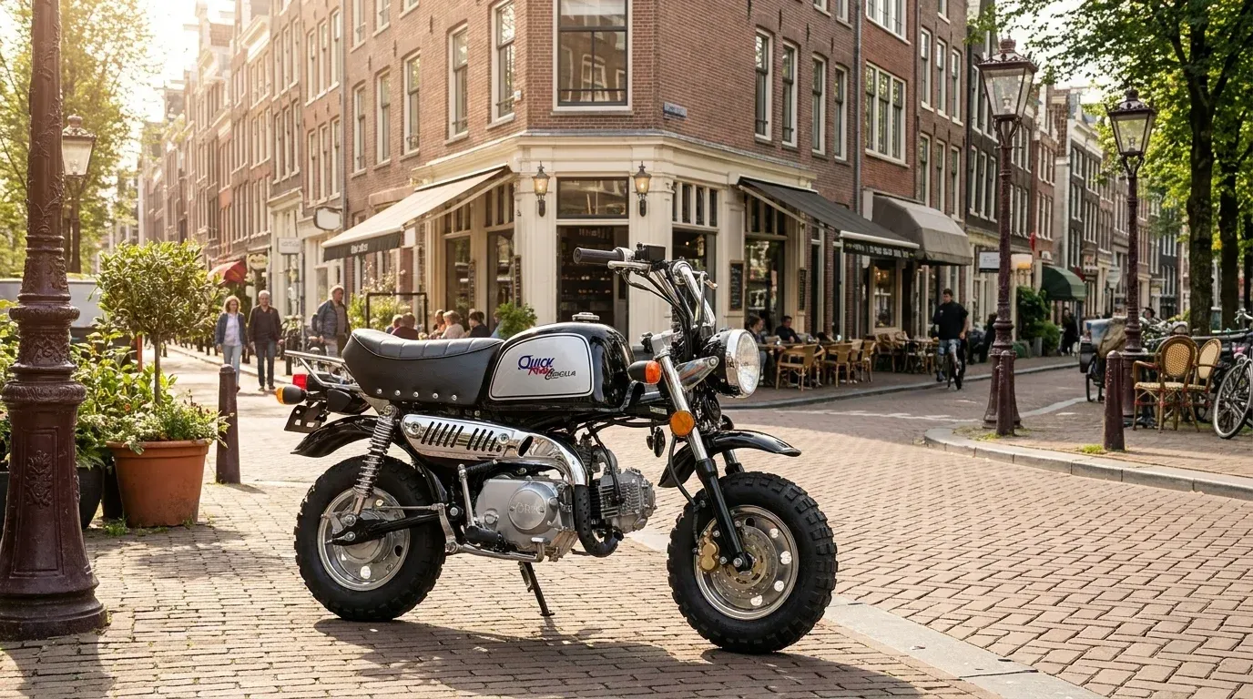 Small black and silver motorcycle parked on a cobblestone street in a sunlit urban area with brick buildings and outdoor cafes.