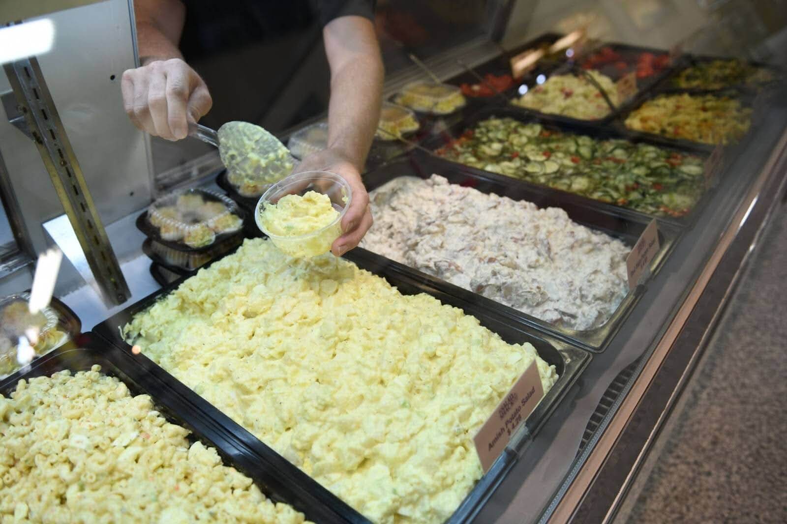farmers market merchant dishing out some fresh amish potato salad 