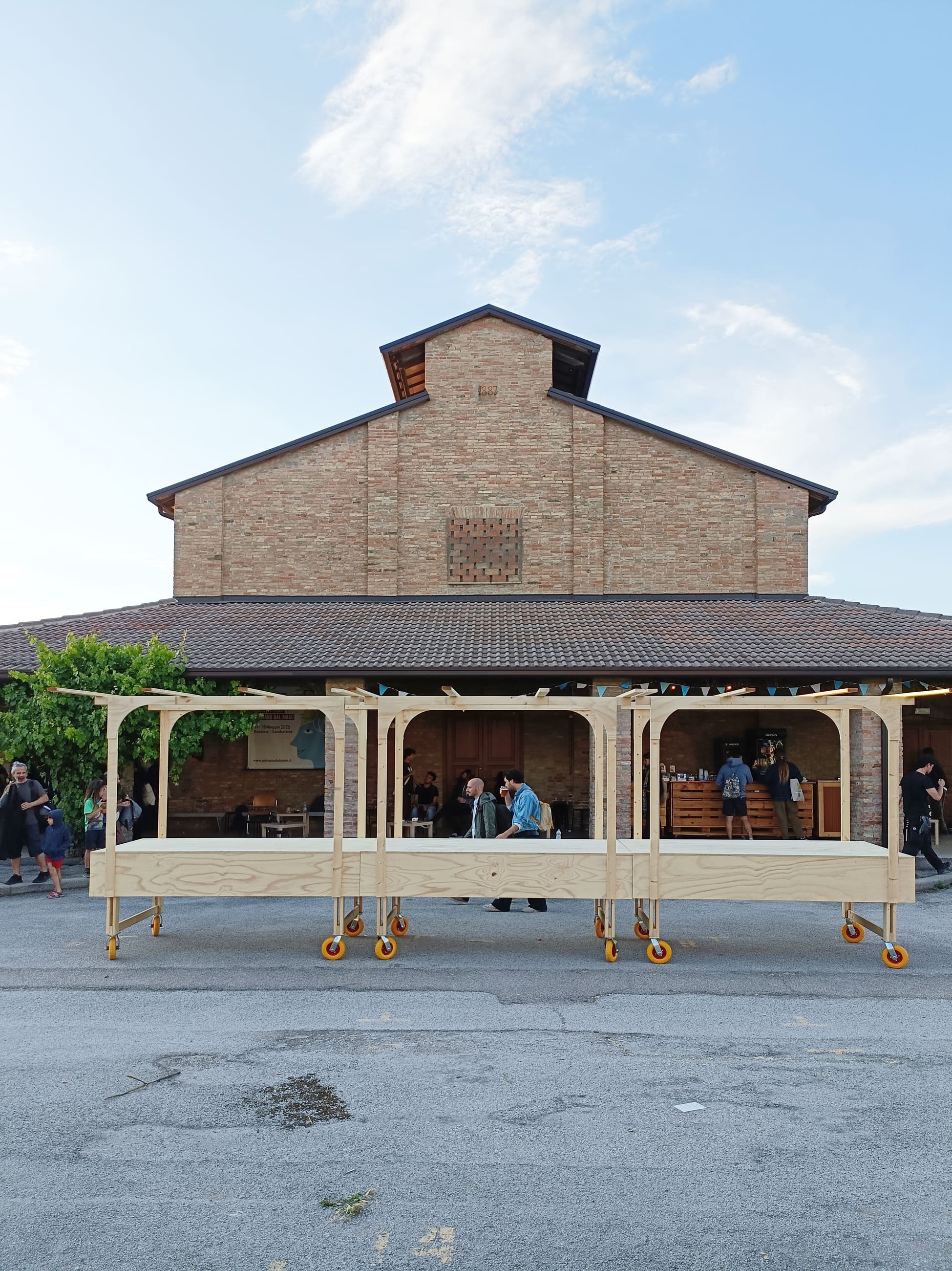 Lungo bancone in legno su ruote davanti a un grande edificio in mattoni