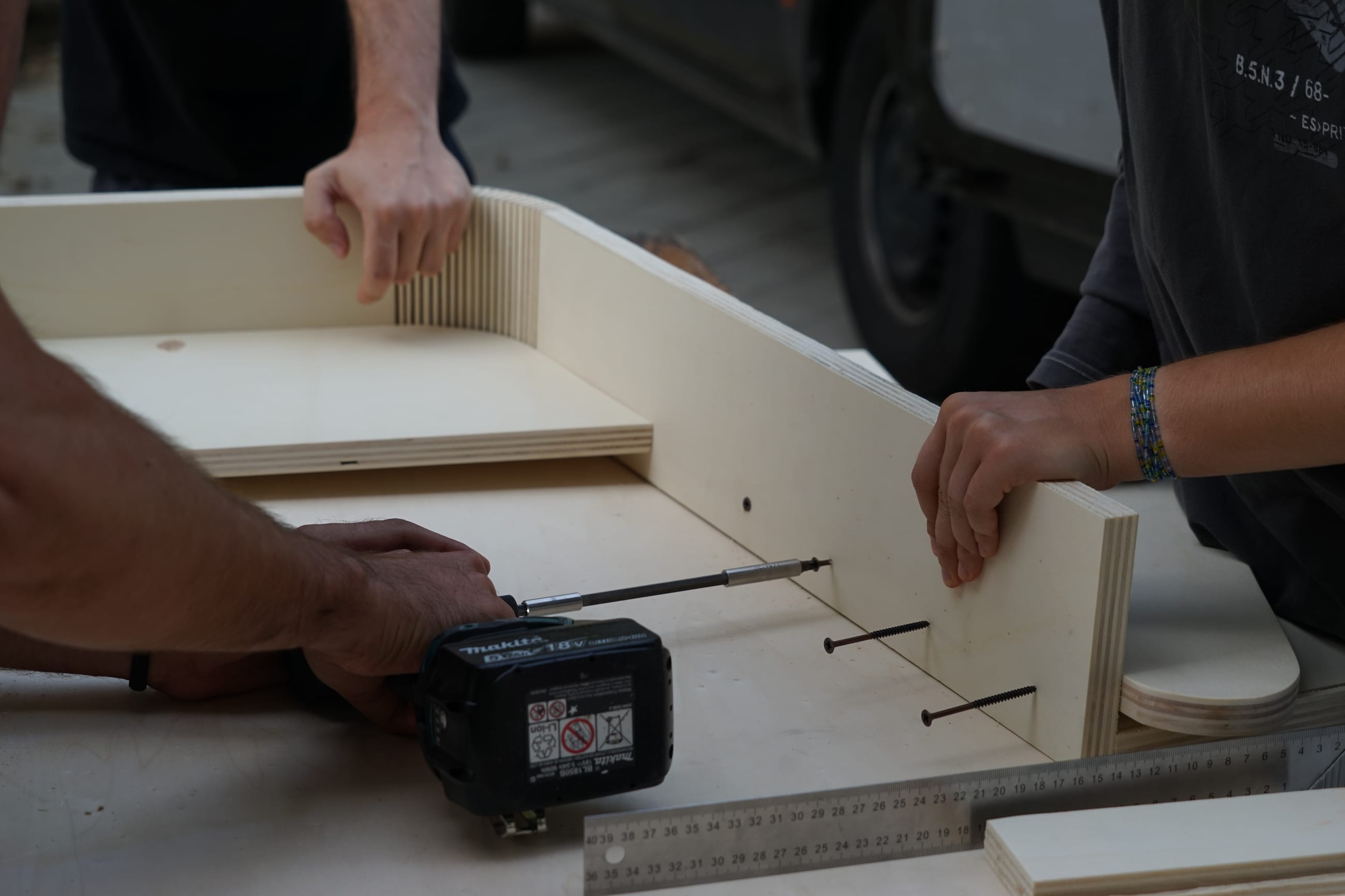Mani che assemblano pannelli in legno con un avvitatore