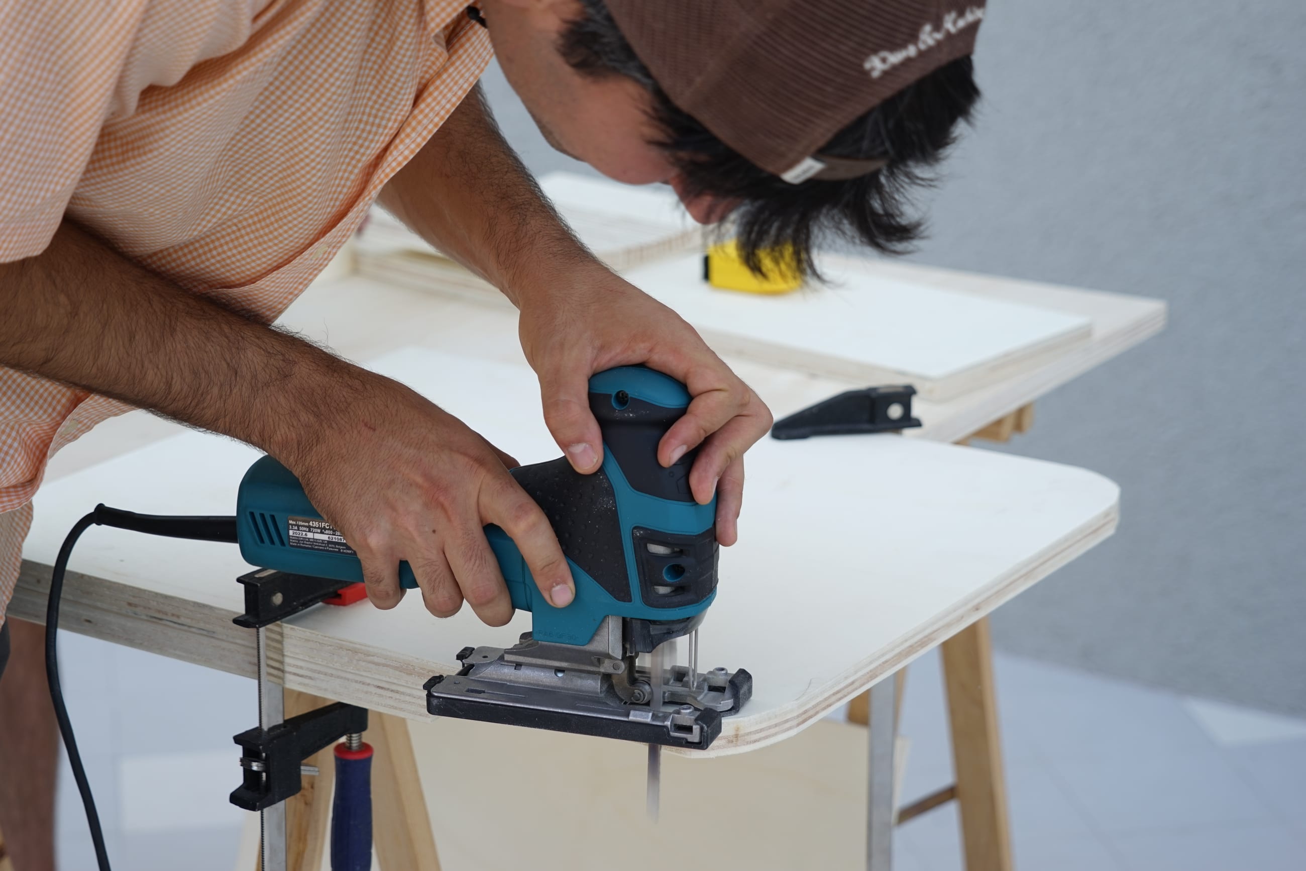Persona taglia un pannello in legno con un seghetto alternativo