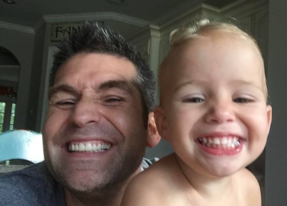 Todd Dunphy with a child, candid smile