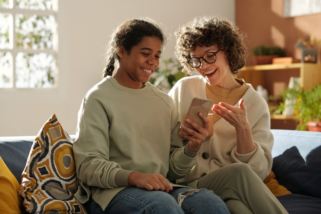A young person and carer smiling together at home