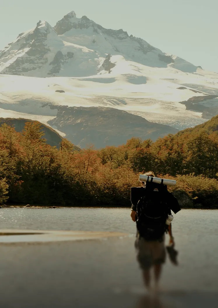 Mujer sonriente colgando un cartel de abierto en la entrada de una tienda.