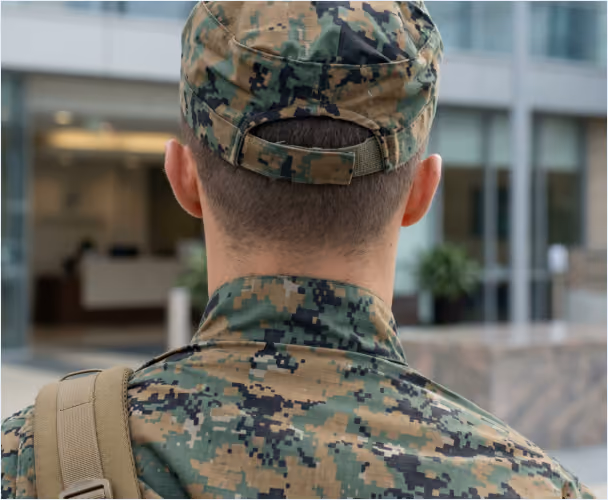 Service member in camouflage uniform seen from behind